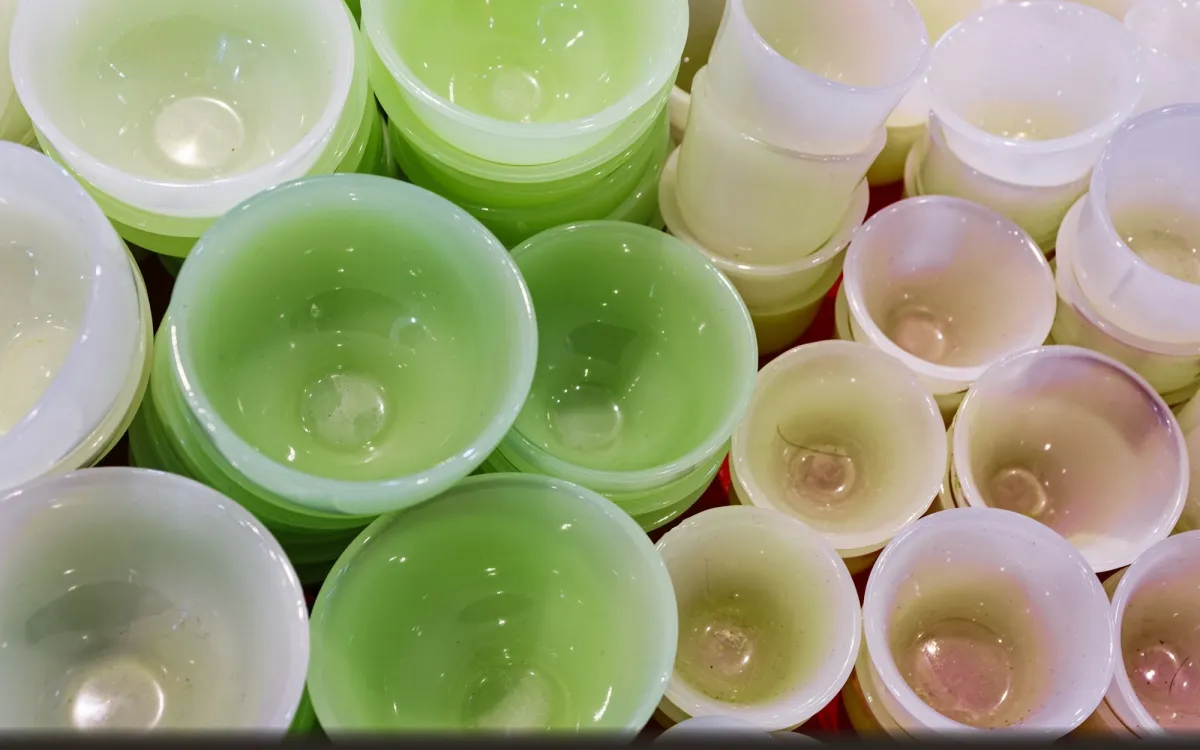İç içe istiflenmiş yeşil ve krem renkli ince plastik kaplar